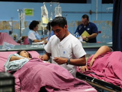 Un enfermero atiende a una paciente en la sala de urgenicas del hopital San Juan de Dios de Ciudad de Guatemala. 