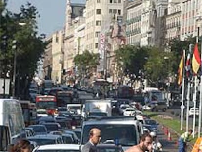 Un ciclista cruza por un paso de peatones de la madrileña calle de Alcalá, llena de coches esta mañana.