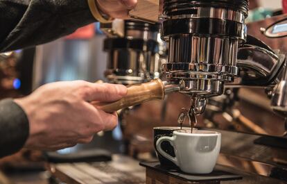 Un camarero prepara un café en un bar de Milán.