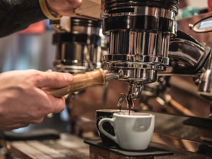 Un camarero prepara un café en un bar de Milán.