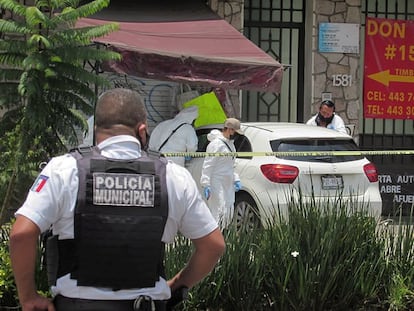La policía municipal y agentes periciales inspeccionan la escena del crimen donde fue asesinado el periodista mexicano Abraham Mendoza, en Michoacán este lunes.