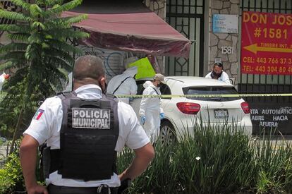 La policía municipal y agentes periciales inspeccionan la escena del crimen donde fue asesinado el periodista mexicano Abraham Mendoza, en Michoacán