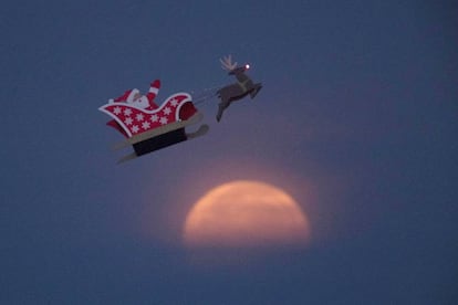 Una figura de Santa Claus de control remoto vuela cerca de la Superluna en Carlsbad, California (EE UU), el 3 de diciembre de 2017.