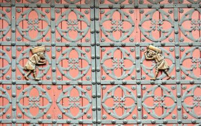 Detalle de la puerta principal de Santa María del Mar, con dos 'bastaixos' que llevan sobre los hombros las piedras desde la cantera real de Montjuïc.