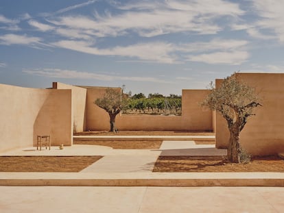 El cerramiento de la parcela deja un hueco en los muros para disfrutar de las vistas sobre un viñedo cercano.