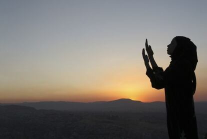 Una niña musulmana de Siria se sitúa en la cima del monte Qassioun, con vistas a la ciudad de Damasco, durante el atardecer y reza en el mes de Ramadán. Imagen del 22 de Agosto del 2010.