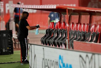 Un trabajador del RCD Mallorca desinfecta el banquillo en el estadio de Son Moix