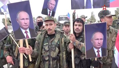 Fotograma de un vídeo de tvzvezda.ru que muestra a soldados sirios que sostienen carteles con el rostro de Putin.