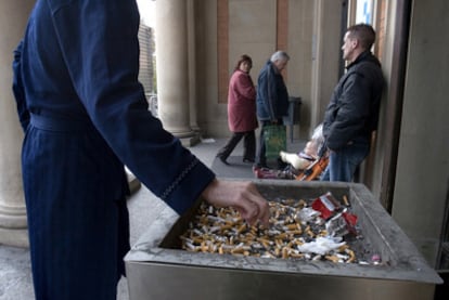 Un enfermo apaga su cigarrillo a las puertas del Hospital Vall d'Hebron (Barcelona).