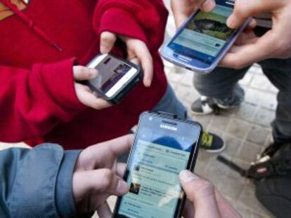 Jóvenes estudiantes de instituto conectados a las redes sociales.