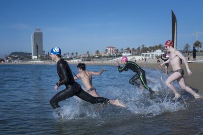 Varios bañistas se lanzan al mar en la playa de Bogatell, en Barcelona, durante la reapertura parcial de las playas tras el confinamiento por la pandemia de coronavirus, el 8 de mayo.