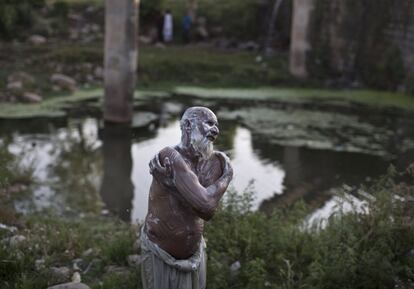 Un vendedor de verduras paquistaníes se baña cerca de una tubería de suministro de agua, en las afueras de Islamabad, Pakistán.