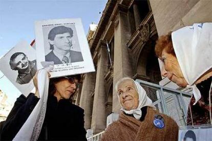 Miembros de Madres de la Plaza de Mayo muestran las fotos de sus familiares junto a la Corte Suprema en Buenos Aires.