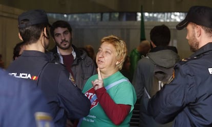 Una de las personas que protestan contra la venta de pisos públicos habla con un policía.