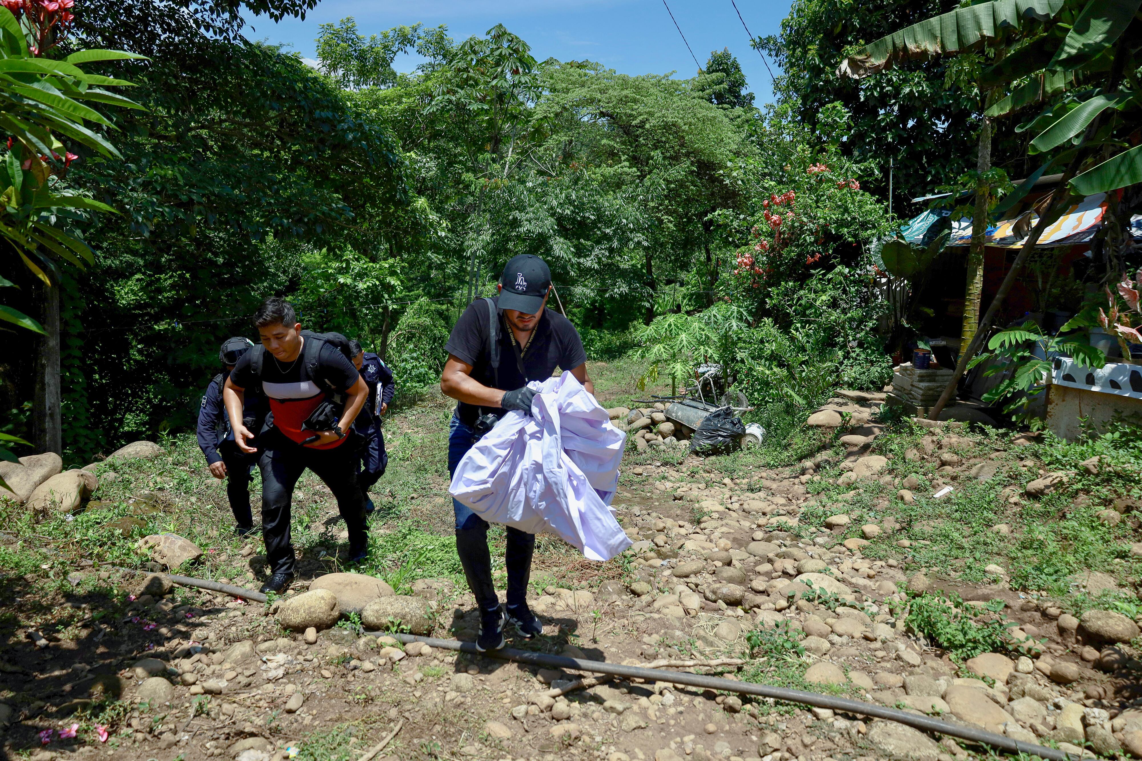 Policías trabajan en una zona del río Cahoacán donde fueron localizados restos humanos.