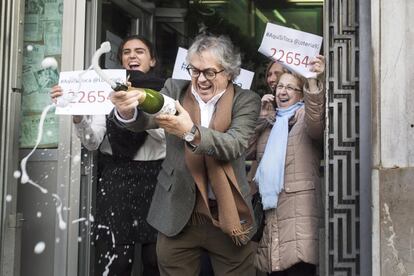 En la imagen Pedro Fortuño, dueño de la administración de lotería de la plaza Urquinaona de Barcelona, donde se vendió parte del primer premio del sorteo de El Niño, celebrando su buena suerte.