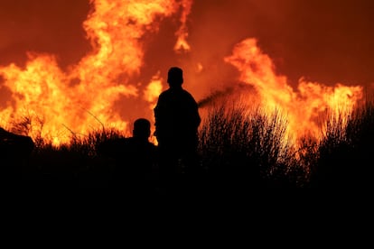 Varios bomberos participan en la extinción del incendio en Dionysos, el lunes. 