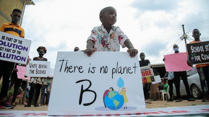 Un niño y otros jóvenes activistas  ugandeses contra el cambio climático se manifiestan en el barrio de Luzira de Kampala.
