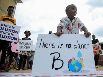 Un niño y otros jóvenes activistas  ugandeses contra el cambio climático se manifiestan en el barrio de Luzira de Kampala, Uganda, el 25 de septiembre de 2020.