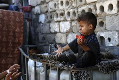 Un niño paquistaní come un tomate en un barrio de bajos recursos, en la Franja de Gaza.