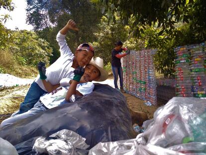 Una vez se tiene el suelo ya cementado, es el momento de pasar a las paredes. Mientras que a ras de suelo se pueden echar las botellas casi directamente, para los muros hay que crear unas mallas llenas de botellas de tamaño medio. Es un proceso manual y bastante pesado, en el que se usa un palo para desplazarlas por la estructura.




