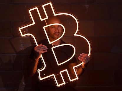 Pau Ninja poses with a neon Bitcoin symbol.