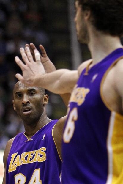 Bryant y Gasol chocan las palmas durante un partido.