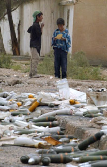 Unos niños, ayer en Basora, junto a unos proyectiles sin explotar.