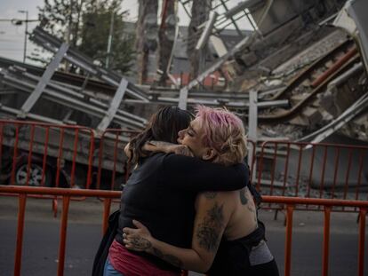 Dos mujeres lloran la perdida de una amiga frente a donde ocurrió el accidente de la linea 12 del metro en Ciudad de México el día 08 de mayo de 2021.