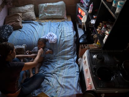 Dara Oliveira da de comer a su hija en su casa en una área ocupada por cientos de familias pobres en Río de Janeiro (Brasil). Oliveira está criando a su hija sola y depende de la ayuda alimentaria para su subsistencia.