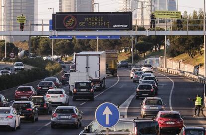 Activistas de Greenpeace durante una acción en la M-30 para denunciar la contaminación en Madrid. 