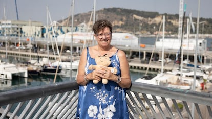 Maria Rosa Madonar, voluntaria de la Copa América de Vela que se celebrará en Barcelona en 2024, fotografiada frente a la base del equipo italiano Luna Rossa en el puerto de Barcelona junto a un muñeco del Cobi, icono de los Juegos del 92.