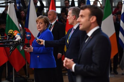 La canciller alemana, Angela Merkel, lanza una mirada al presidente francés, Emmanuel Macron, durante una breve comparecencia de ambos ante los medios de comunicación en el Consejo Europeo de este miércoles.