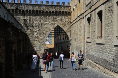 Varios viandantes cruzan las murallas de la almendra medieval 