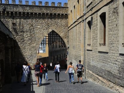 Varios viandantes cruzan las murallas de la almendra medieval 