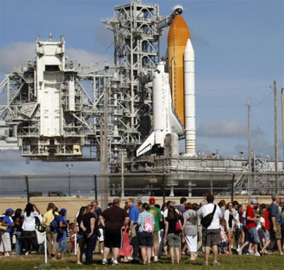 Turistas contemplan los preparativos para el lanzamiento este lunes del trasbordador espacial.