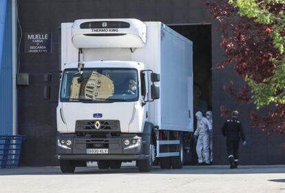Miembros de la Unidad Militar de Emergencias (UME) trasladan los féretros en camiones frigoríficos al Palacio de Hielo de Madrid.
