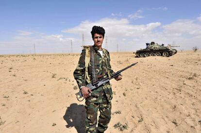 Un rebelde posa frente a un carro de combate, cerca del frente de Ajdabiya. Gadafi, que siempre había desconfiado del este, había nutrido con las armas más obsoletas esta zona, concentrando sus fuerzas cerca de la capital. El rebelde porta un ametralladora desmontada de 7 milímetros.