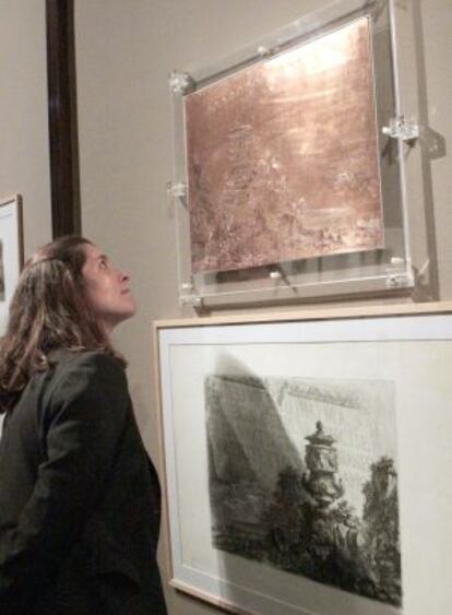 Una mujer contempla la plancha de cobre de Piranesi que se exhibe en la pìnacoteca bilbaína.