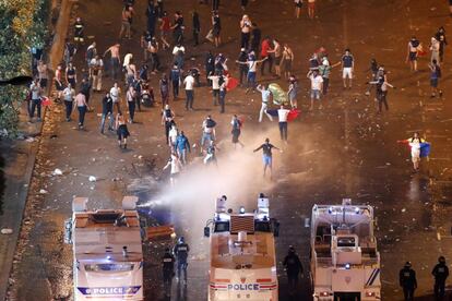 A polícia dispersa os torcedores com jatos de água em frente à Champs-Élysées.