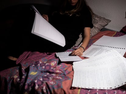 Una joven estudia en su cama para preparar el examen de selectividad.