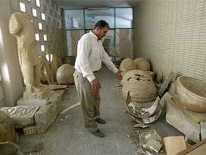 Un iraquí muestra objetos históricos destrozados en el Museo Arqueológico de Bagdad.