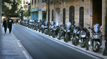 Motos aparcadas en la acera en una calle de Valencia hace unos a&ntilde;os.