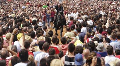 Un jinete atraviesa la multitud en Ciutadella el 24 de junio.