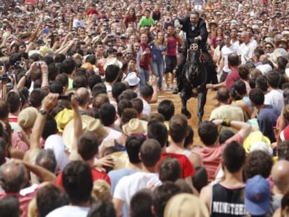 Un jinete atraviesa la multitud en Ciutadella el 24 de junio.