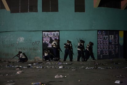 Varios policías se protegen durante las protestas en las calles de Petion Ville, Puerto Príncipe (Haití), tras el anuncio de los resultados de las elecciones presidenciales, que han dado la victora en la primera vuelta de las presidenciales a  Mirlande Maniga con el 31,37% de los votos y que competirá en segunda ronda con el oficialista Jude Celestin, que obtuvo el 22,48%.