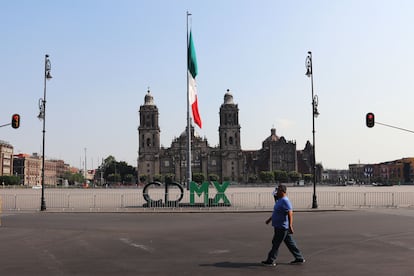 Un hombre camina por un costado de la desolada explanada del Zócalo.