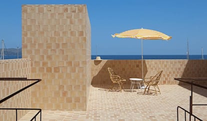 La terraza del apartamento de la segunda planta tiene vistas a la bahía de Alcúdia, en el norte de la isla de Mallorca. El espacio está totalmente revestido con baldosa de barro tradicional, un material típico de la zona y que se fabrica en la localidad de Felanitx, situada al sur.