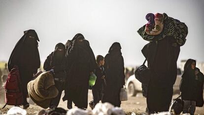 Mujeres con niños abandonaban Baghuz (Siria) arrastrando sus pertenencias, el 5 de marzo.