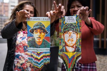 Gladys Acevedo y Delsa Vanegas, madres de soldados asesinados de la fundación madres de Color y Esperanza por Nuestros Héroes, sostienen un tejido de uno de sus hijos.